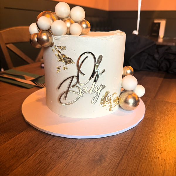 Oh Baby cake topper on baby shower cake in gold acrylic